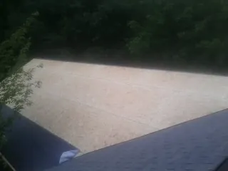 New OSB roof sheathing installed beside an existing shingle roof in Beverly