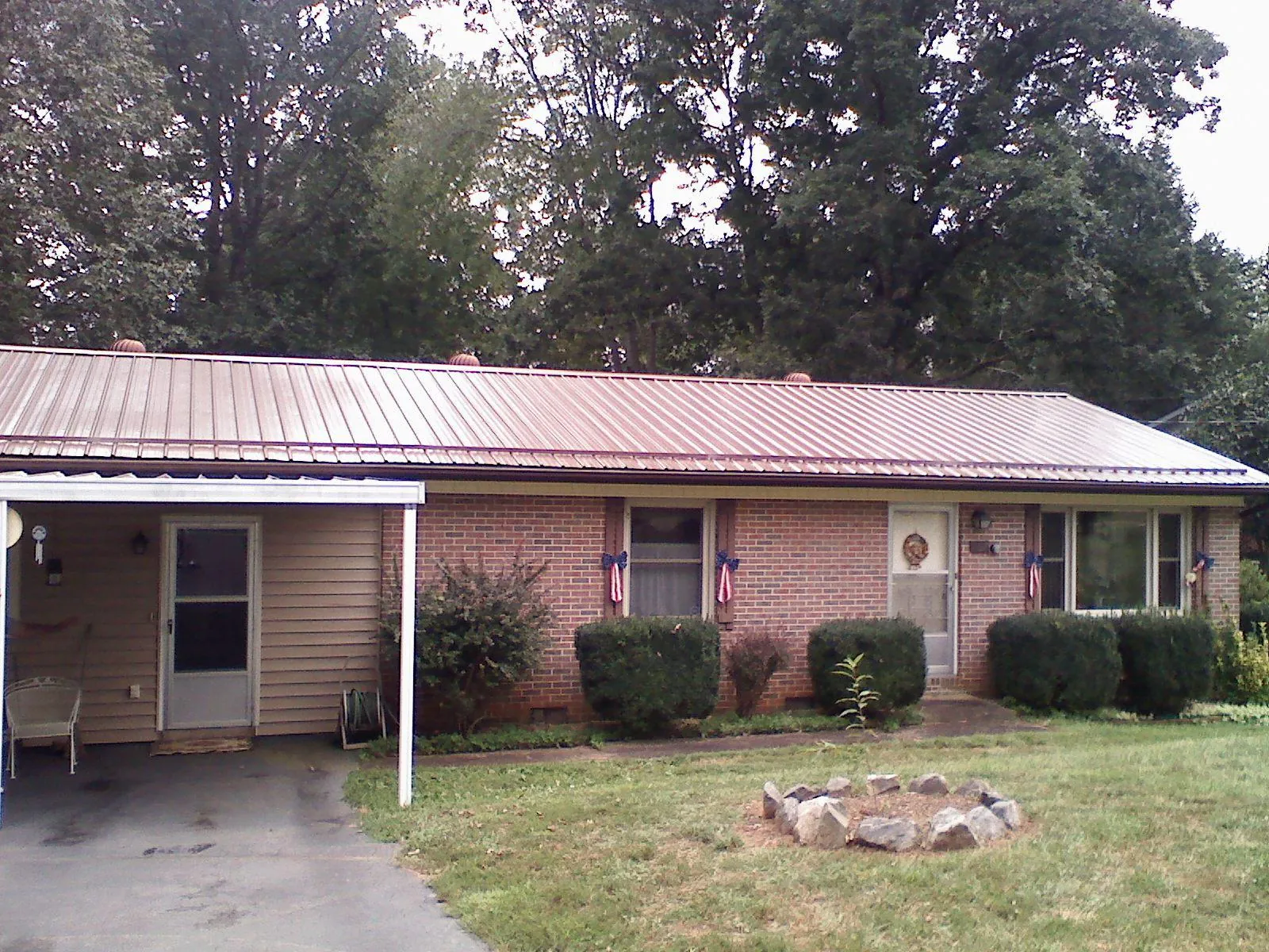 Bronze metal roof and carport on a brick ranch home — Roof Repair work by our crew in Beverly